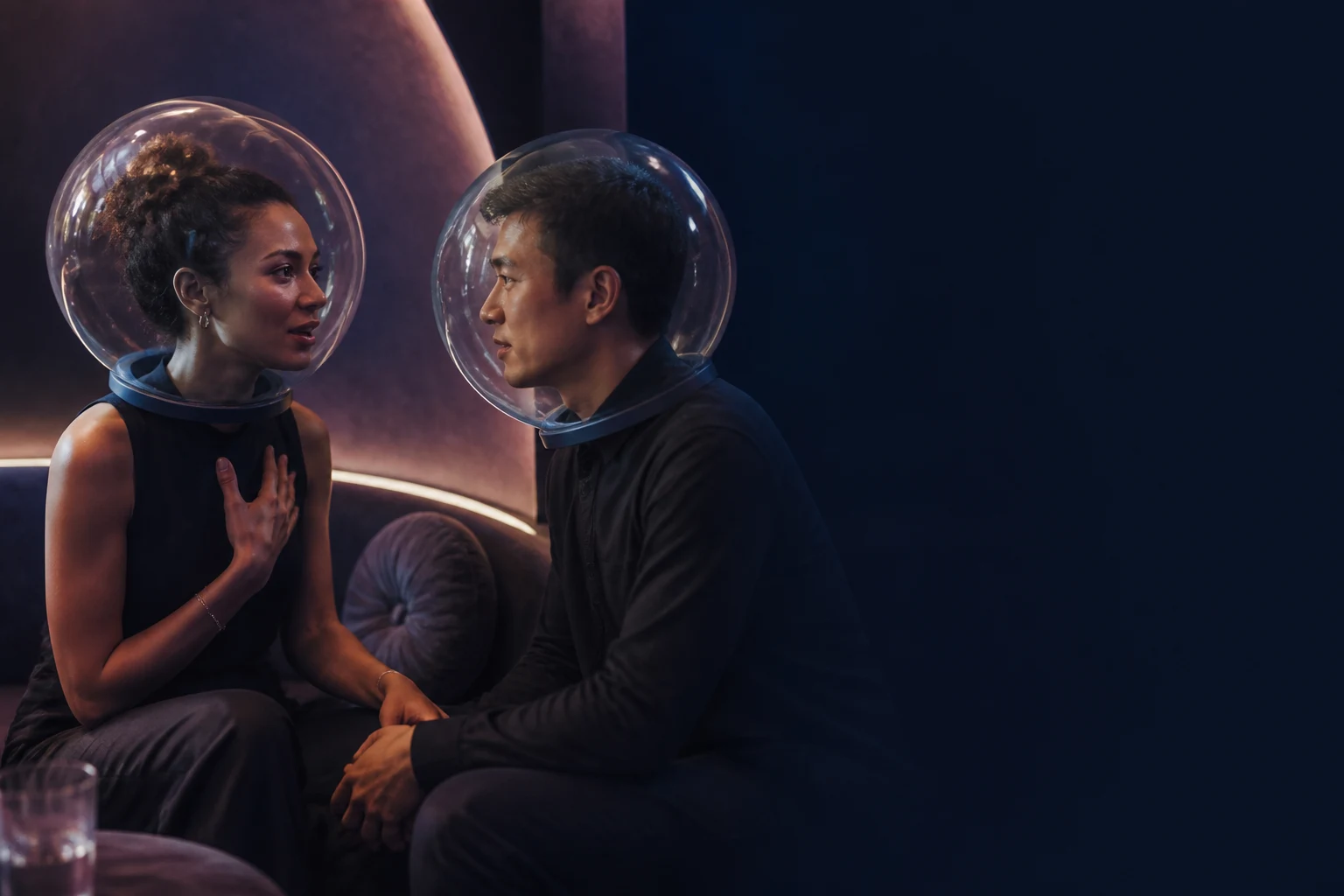 Two people in transparent helmets share an emotionally intense conversation without understanding the words